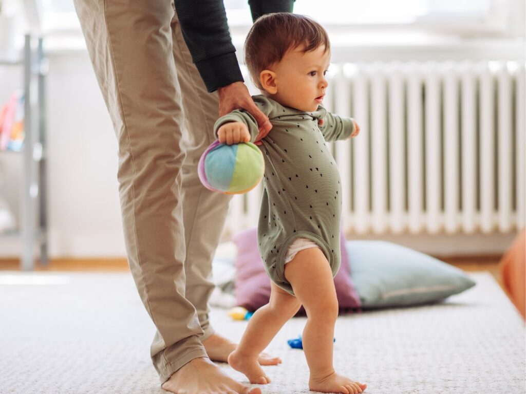 Niño caminando con la ayuda de su madre