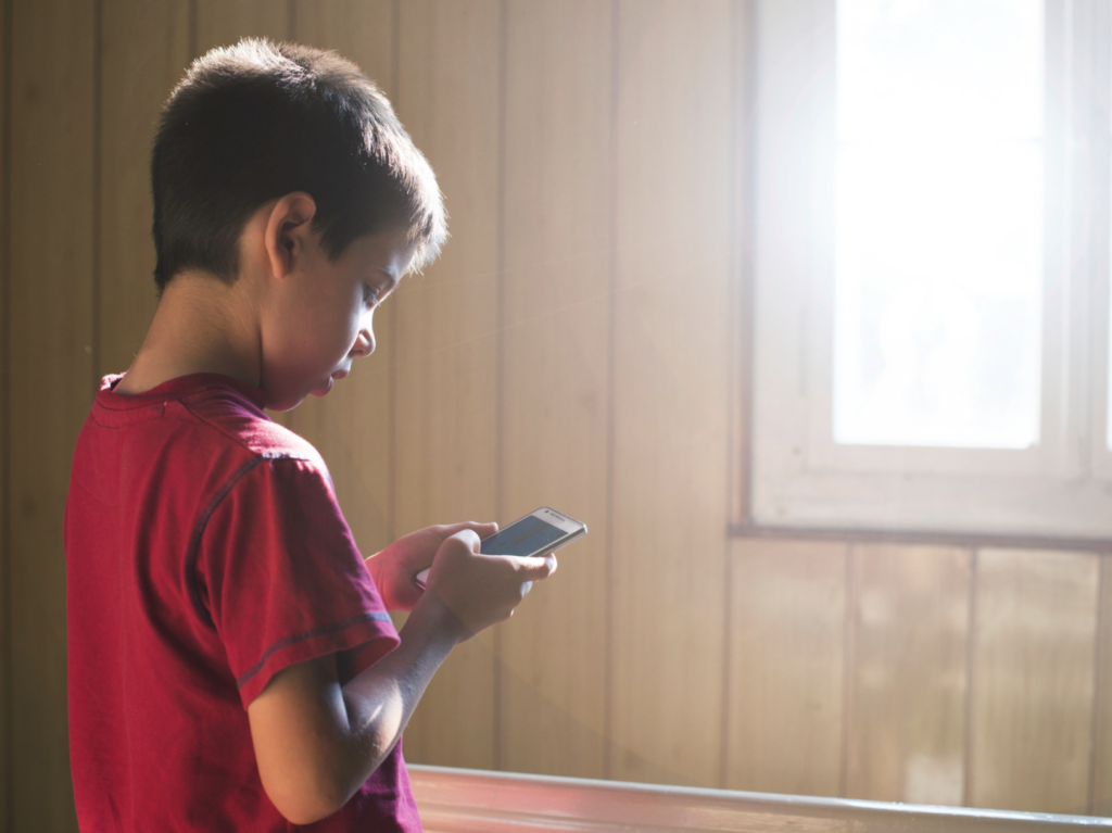 Niño perdiendo el tiempo en el celular