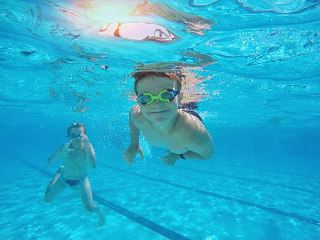 Niño sumergido en una piscina, sonriendo