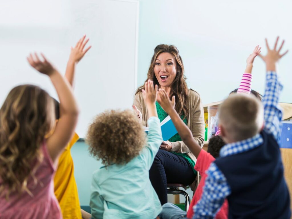 Niños alzando la mano para participar en una actividad social