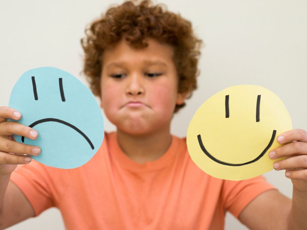 Niño evaluando si se siente feliz o triste