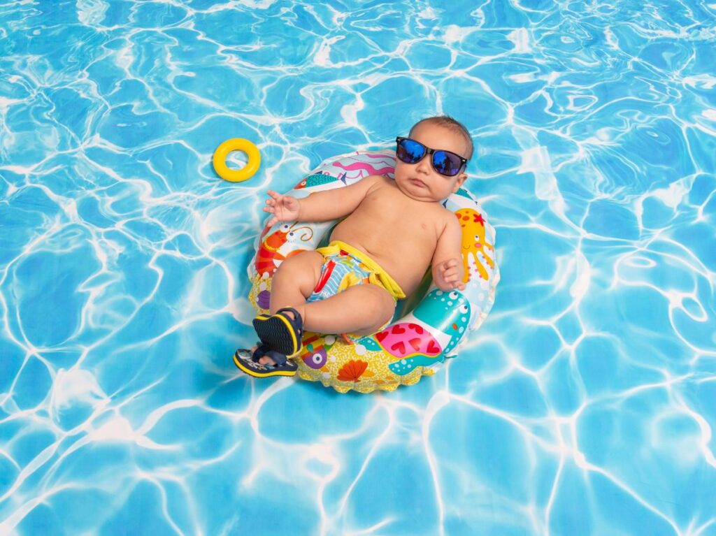 Un bebé aprendiendo a nadar desde pequeño, eun una piscina