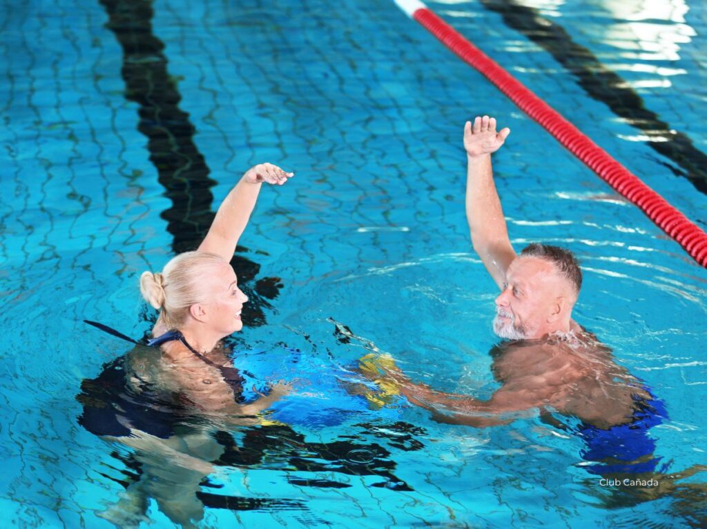Una pareja de adultos mayores practicando aquafitness