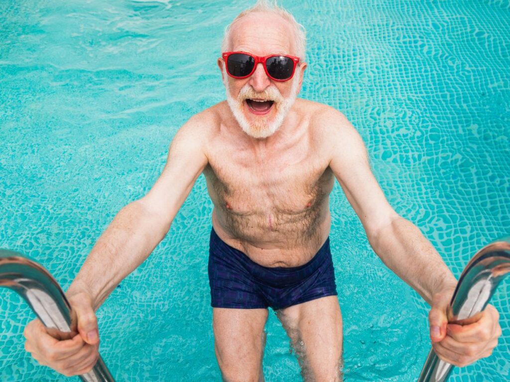 Persona de la tercera edad contento saliendo de una alberca