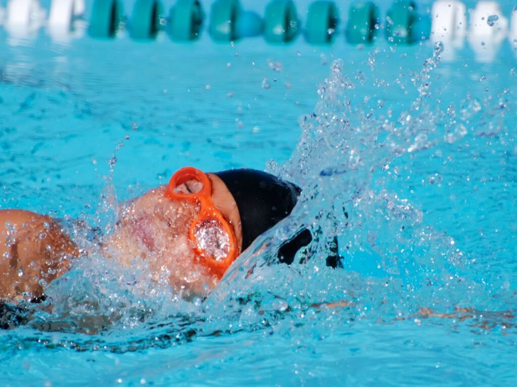 nadador practicando ejercicios de respiración en natación para adultos en una piscina