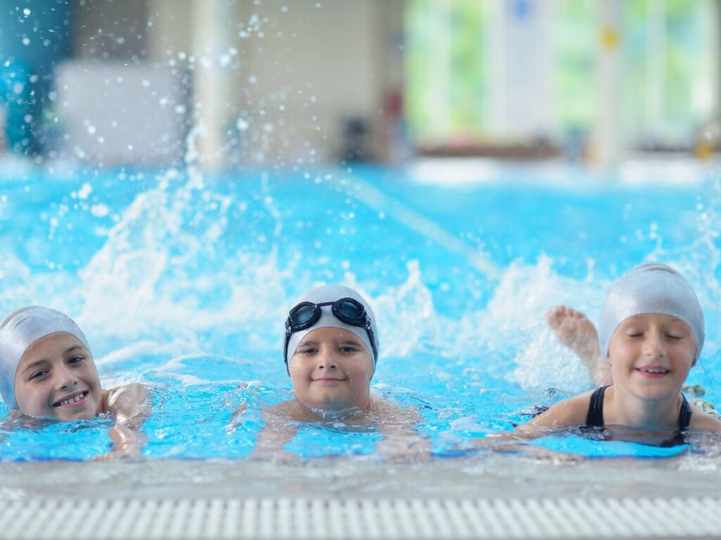 Infantes practicando ejercicios de natación para desarrollar habilidades motoras en niños