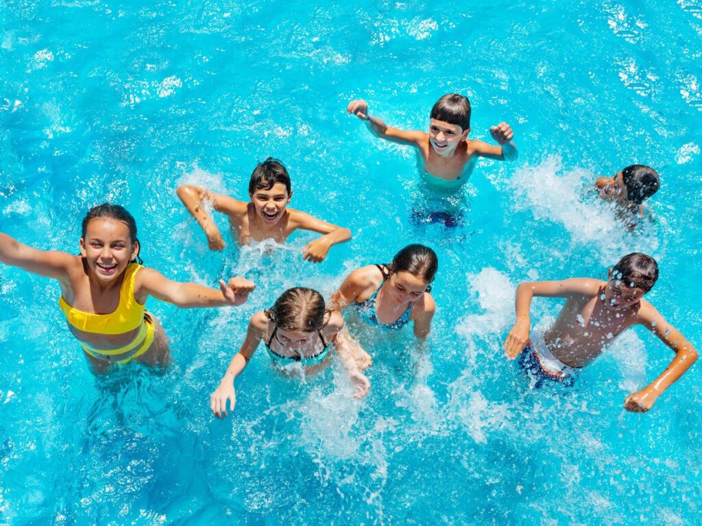 Niños socializando, felices en una alberca