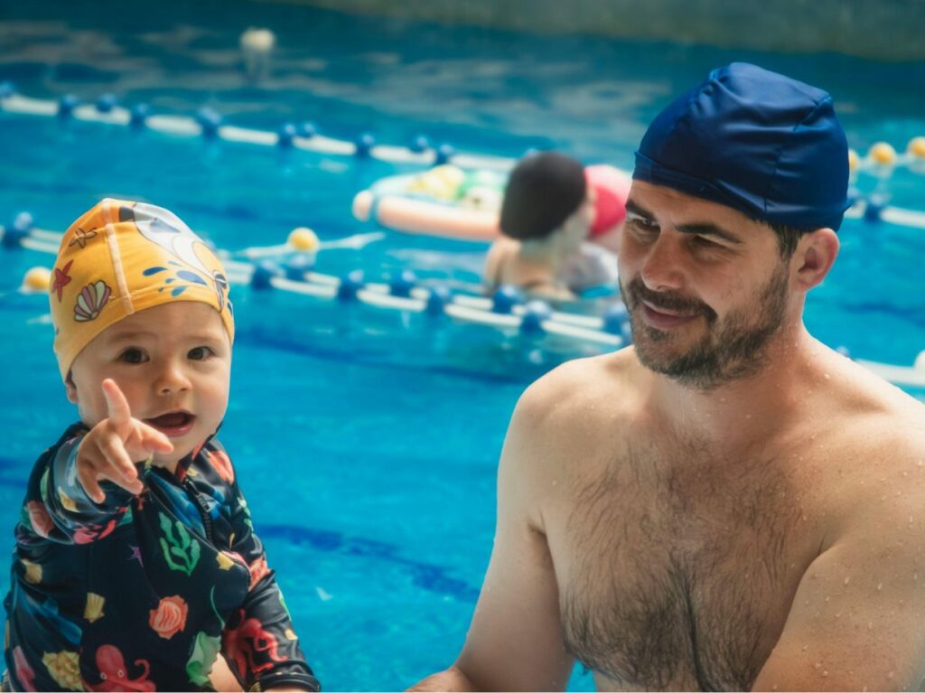 Un padre y su hijo, saliendo de nadar de una pisicina