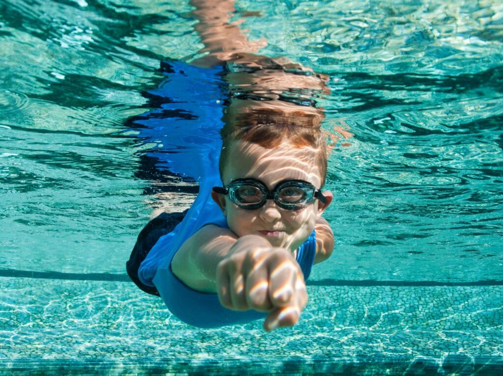 Un niño haciendo un ejercicio de natación para mejorar la capacidad pulmonar infantil