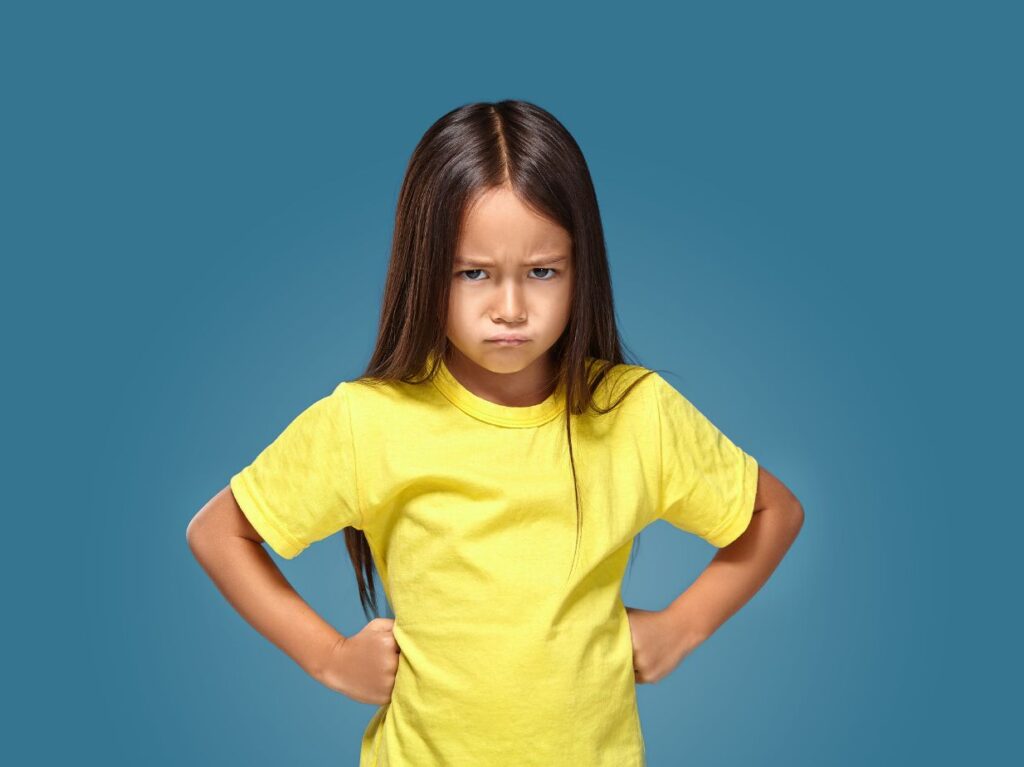 Niña enojada con camiseta amarilla