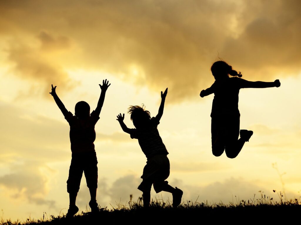 Niños saltando, porque conocen la importancia del movimiento en el desarrollo cognitivo infantil