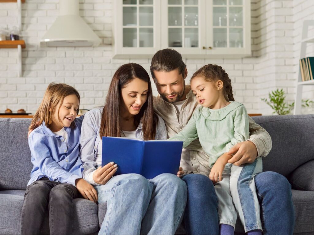 Unos padres leyendo un cuento a sus hijos, porque saben cómo mejorar la comunicación con niños pequeños