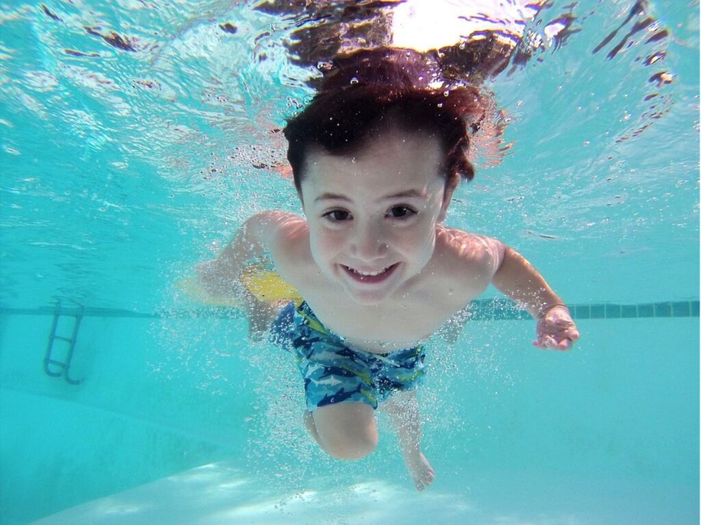 Un bebé tomando clases de natación abajo de una pisicina