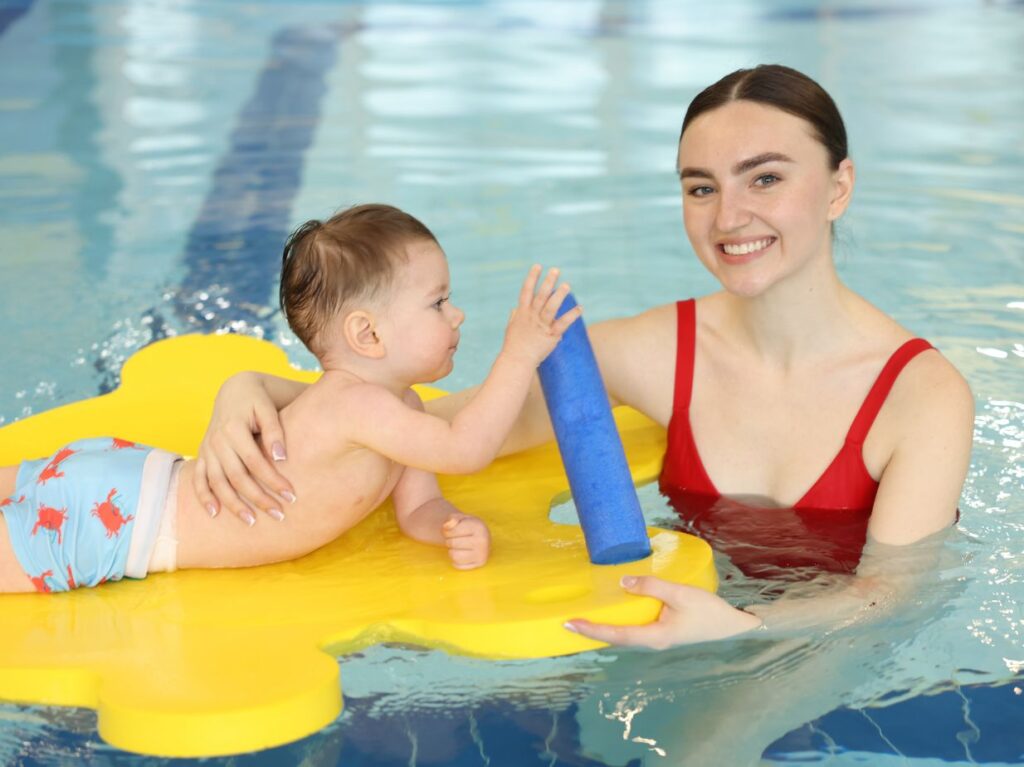 Mamá con bebé que está empezando a aprender a nadar